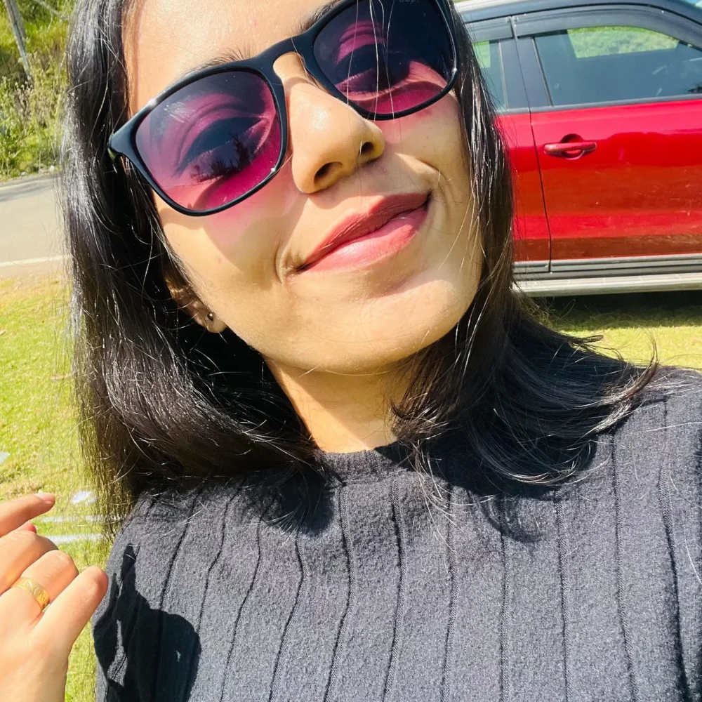 a lady with glasses & smiling face facing camera